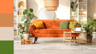 Kahverengi kanepesi, çiçekleri, masa ve aynası olan şık bir oturma odası. Farklı renk desenleri