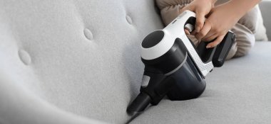 Kadın eli elektrikli süpürge koltuğu, yakın çekim.