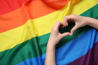 Elleriyle LGBT bayrağını taşıyan bir kadın