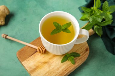 Tahta tahta tahta, taze nane çayı ve grunge yeşil arka planda zencefil kökü.