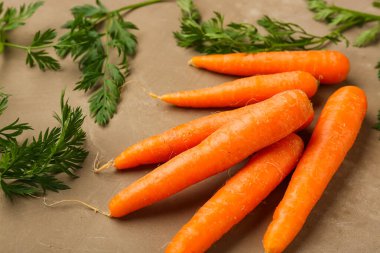 Kahverengi arka planda bir sürü taze havuç