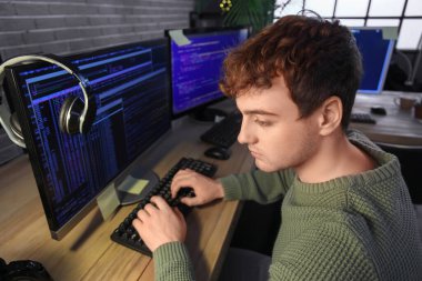 Geceleri ofiste bilgisayarla çalışan erkek programcı, yakın plan.