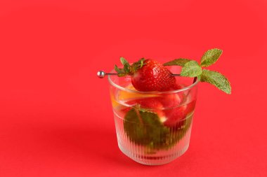 Kırmızı arka planda çilekli ve limonlu taze limonata.