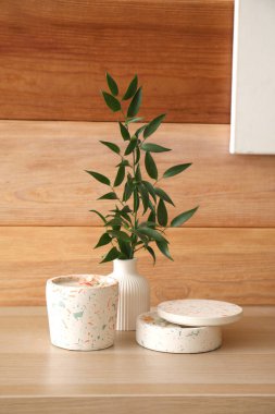 Odanın ahşap duvarının yanındaki masada güzel bir dal ve mumlar var.