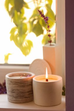 Pencere pervazında yanan mumla tutucu, yakın plan.