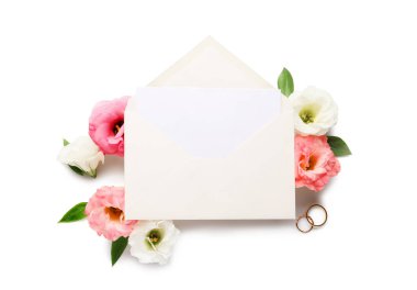 Zarflı kompozisyon, boş kart, alyans ve beyaz arkaplanda östoma çiçekleri