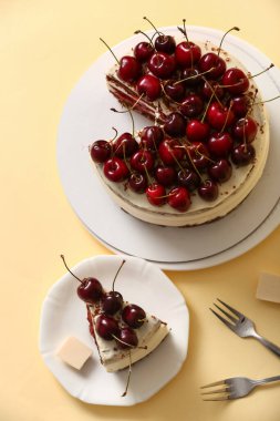 Sarı arka planda lezzetli vişneli kek tabakları