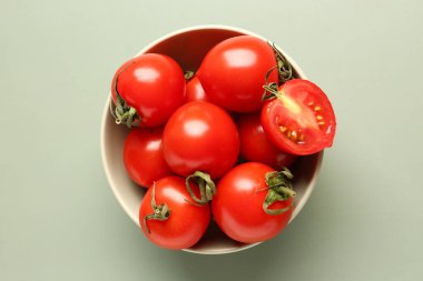 Gri arka planda taze vişne domatesli kase