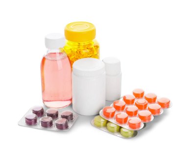 Beyaz arka planda farklı haplar ve ilaç şişeleri