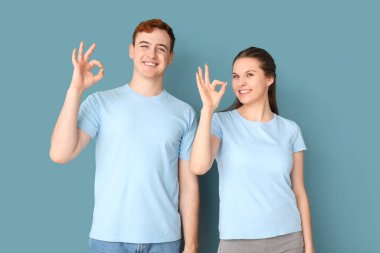 Tişörtlü genç çift mavi arka planda iyi görünüyor.