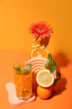 Turuncu arka planda meyve ve çiçekli lezzetli narenciye kokteyli.