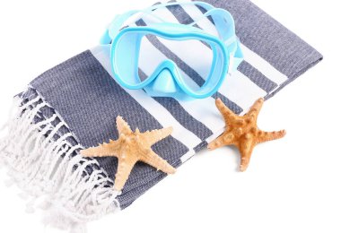 Yeni yüzme maskesi, deniz yıldızları ve beyaz arka planda havlu.
