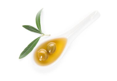 Beyaz arka planda bir kaşık taze zeytinyağı