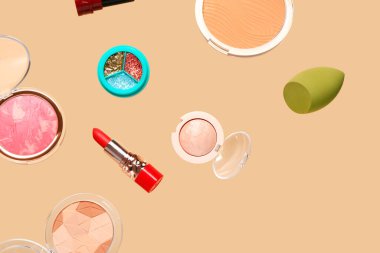 Uçan dekoratif kozmetik soluk turuncu arka planda