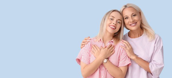 Счастливая молодая женщина с матерью на светло-голубом фоне с пространством для текста