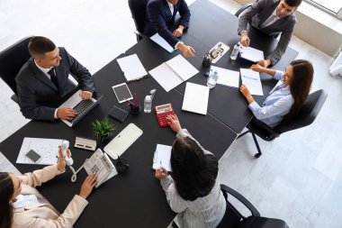 Toplantı salonundaki masada çalışan bir grup iş adamı.