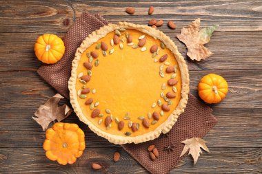 Bademli balkabaklı tart ve ahşap zemin üzerinde tohumlar.