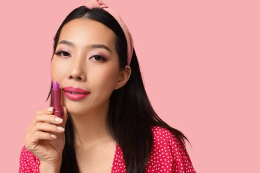 Pembe arka planda ruj izi olan güzel Asyalı kadın.