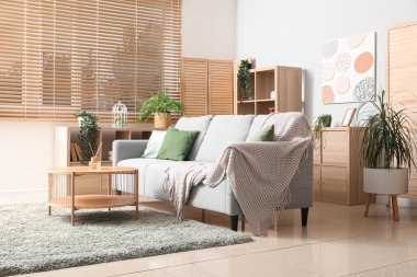 İçinde kanepe, masa ve bitkiler olan rahat bir oturma odası.