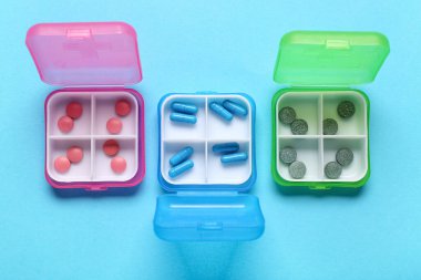 Mavi arka planda farklı haplar bulunan kaplar