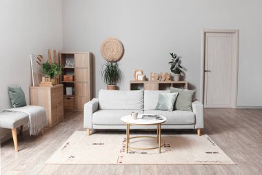 Gri kanepesi ve kahve masası olan modern oturma odasının içinde.