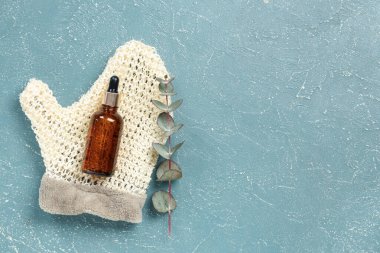 Gerekli yağ şişesi, masaj eldiveni ve renk arkaplanına okaliptüs dalı