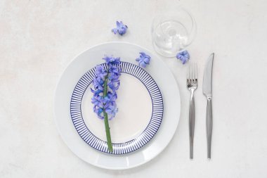 Tabaklar, çatal bıçak takımları, şarap kadehleri ve çiçeklerle dolu güzel bir masa.