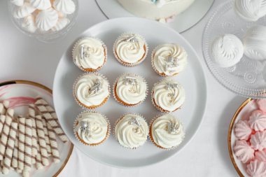 Tatlı standı, lezzetli beyaz kekler ve masadaki doğum günü partisi için diğer tatlılar.