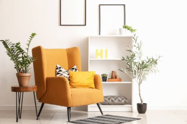 Rahat koltuğu, kahve masası ve zeytin ağacı olan şık bir oturma odası.