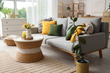 Koltuk, tencere sehpası ve çiçekli hafif konforlu oturma odası.