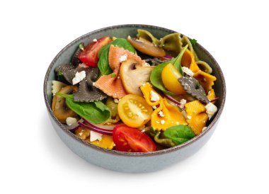 Beyaz arka planda leziz İtalyan makarna salatası ile kase