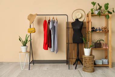 Manken, giysi askılığı ve raf ünitesi olan soyunma odasının içinde.