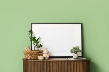 Sepet, ev bitkileri vazosu ve çekmece çerçevesi. Odadaki yeşil duvarın yanında. Yakın çekim.