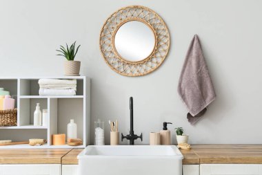 Çiçekler, raf ve banyo aksesuarları banyodaki ışık duvarının yanında.