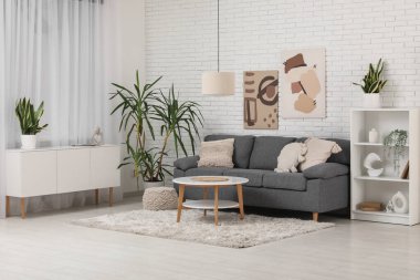 Rahat gri kanepesi ve sehpası olan modern bir oda.