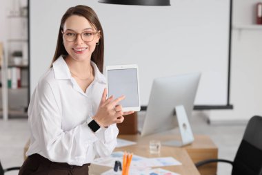 Ofisinde boş tablet bilgisayarı olan güzel sekreter.