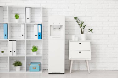 Modern su soğutucusu ve raf ünitesi olan hafif bir ofis.