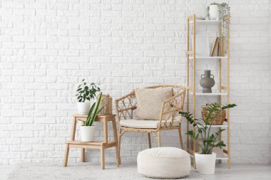 Oturma odasının içinde koltuk, tabure ve raf ünitesi var.