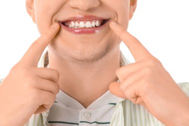 Beyaz arka planda sağlıklı dişleri olan gülümseyen genç adam, yakın plan.