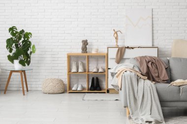 Kanepenin üzerinde dağınık giysiler olan dağınık bir soyunma odası.