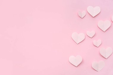 Paper hearts on pink background. Valentine's Day celebration