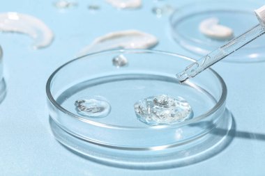 Mavi arka planda numune ve pipet bulunan petri kapları