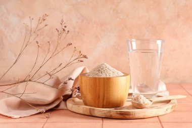 Masada Psyllium kabuğu tozu ve bir bardak su var.