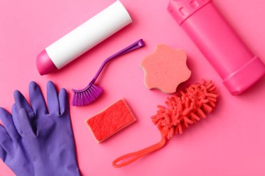 Pembe arka planda temizlik malzemeleri seti, üst görünüm