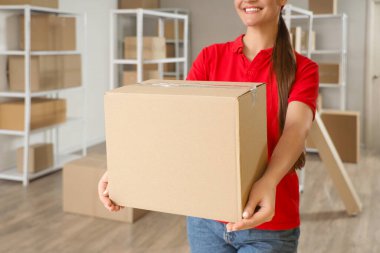 Depoda paket kutusu olan bir kadın işçi.