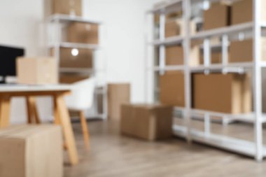 Raf birimleri ve karton kutularla dolu bulanık depo görüntüsü