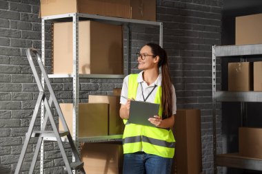 Depoda panosu olan kadın işçi.