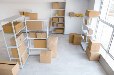 İçinde raf üniteleri, karton kutular ve başlıklar olan hafif deponun içi.