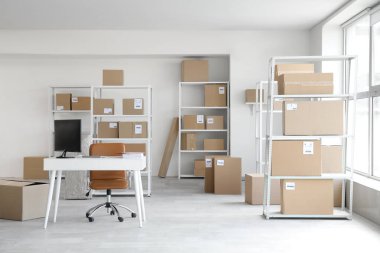 Çalışma yeri, raf üniteleri ve karton kutuların bulunduğu hafif deponun içi.