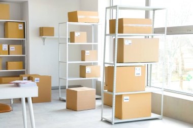 Rafların, karton kutuların ve pencerelerin bulunduğu hafif deponun içi.